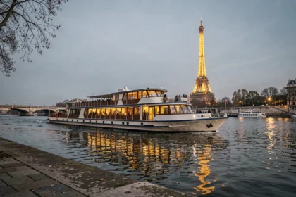 Bateau de dîner croisière sur la Seine avec la Tour Eiffel illuminée en arrière-plan à Paris