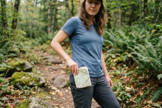 Femme en randonnée ajustant une carte dans la forêt