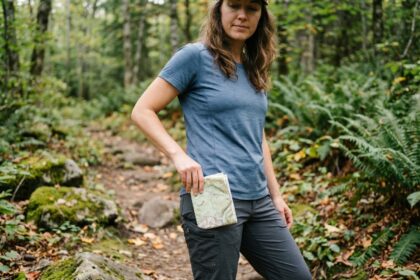 Femme en randonnée ajustant une carte dans la forêt