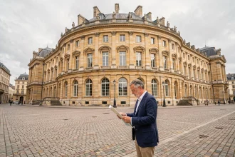 Façade du Palais des Ducs de Bourgogne à Dijon avec un touriste consultant une carte sur la Place de la Libération